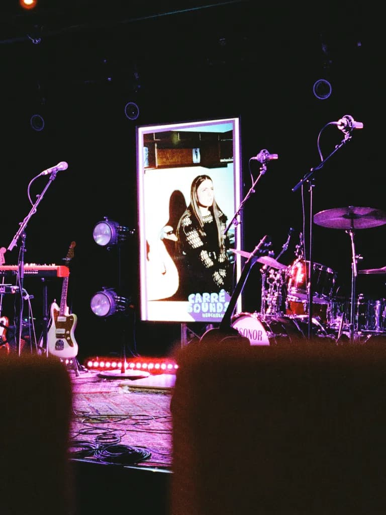 Leere Bühne vor dem Konzert: Keyboard, Gitarre und Schlagzeug stehen bereit, dahinter leuchtet die LED-Wand mit dem Carré-Sounds-Motiv